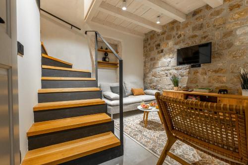 a staircase in a living room with a stone wall at Superior 2 Bedroom Apartment Gabriela in Dubrovnik