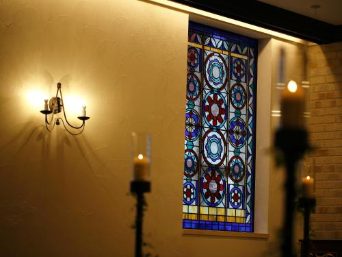a stained glass window on a wall with candles at Hotel Monterey Ginza in Tokyo