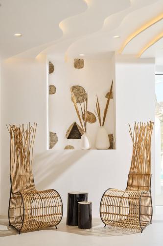 two chairs in a room with vases on the wall at Arte & Mare Elia Luxury Suites and Villas in Elia Beach