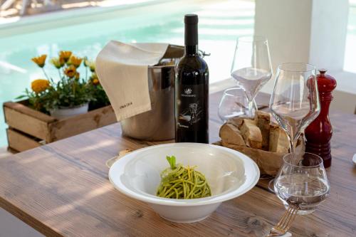 a table with a bowl of green beans and wine glasses at Cala Cala Rooms,Restaurant & Farm Experience in Procida