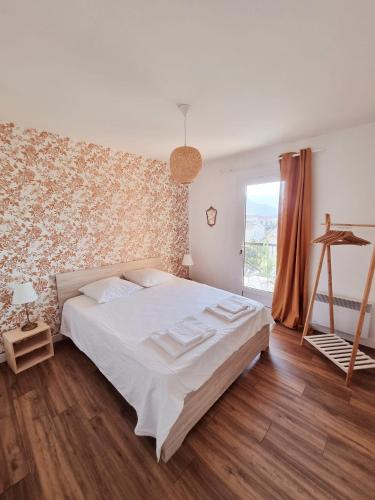 une chambre avec un lit blanc et une fenêtre dans l'établissement Bel appartement centre ville 3 chambres, à Saint-Florent