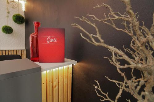 a red bottle sitting on a counter in a room at MY HOME Hotel Lamm Rottweil "Smart Home" in Rottweil