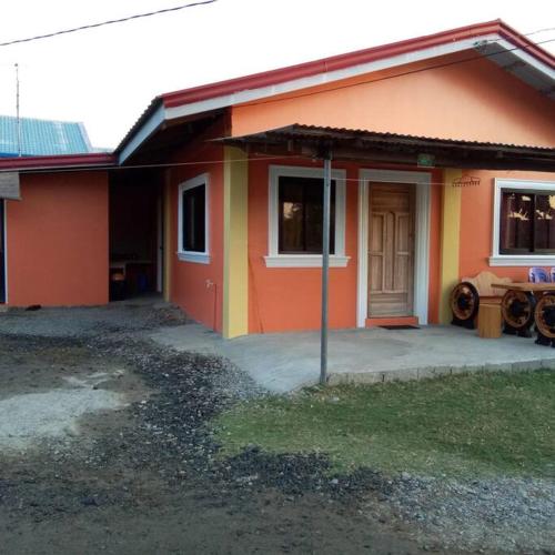 uma pequena casa com um laranja e amarelo em Zeny Milanes Hundred Islands Transient House em Alaminos