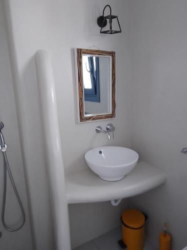 a bathroom with a white sink and a mirror at Annio studios in Plaka