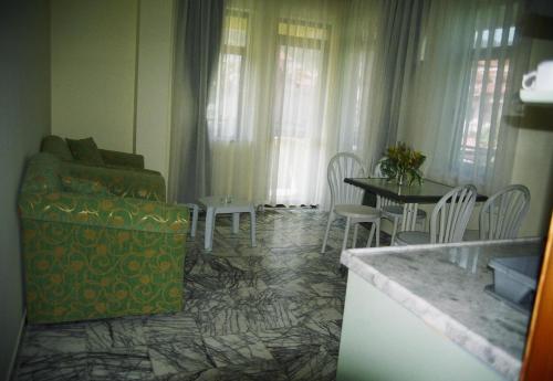 a living room with a couch and a table and chairs at Özay Apart Otel in Muğla