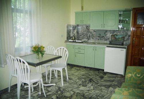 una cucina con armadi verdi, tavolo e sedie di Özay Apart Otel a Muğla