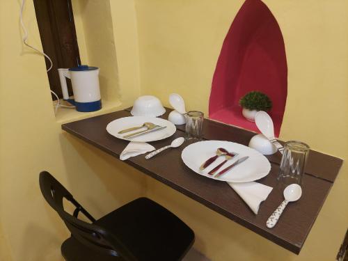 Ani's Homestay في كولْكاتا: طاوله وصحون وأواني ومرآة