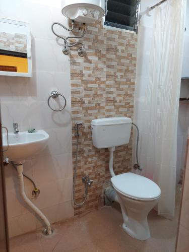 a bathroom with a toilet and a sink at Ani's Homestay in Kolkata