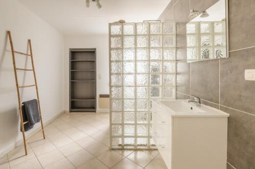 baño con lavabo y pared de cristal en Villa les cigales, en Ouveillan