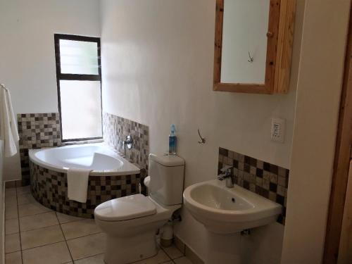 y baño con aseo, bañera y lavamanos. en Herolds Bay Accommodation - Coo-ee 2, en Herolds Bay