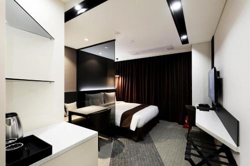 Habitación de hotel con cama y espejo en Kintex by K-tree, en Goyang