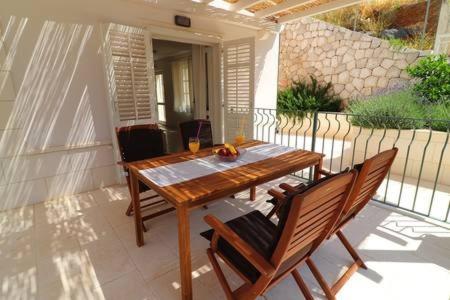 a wooden table and two chairs on a patio at Apartments Seafront Silence in Trstenik