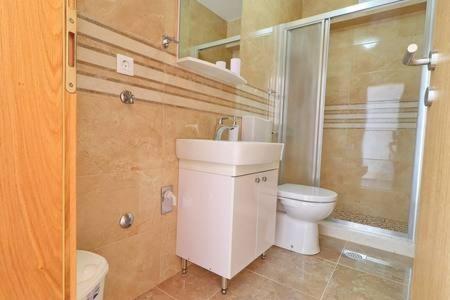 a bathroom with a toilet and a sink and a shower at Apartments Seafront Silence in Trstenik