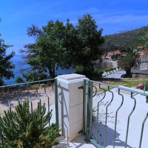 a balcony with a fence and a view of the ocean at Apartments Seafront Silence in Trstenik