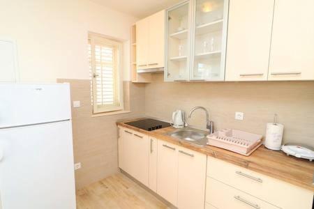 a kitchen with a sink and a white refrigerator at Apartments Seafront Silence in Trstenik