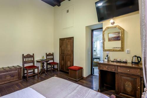 a bedroom with a bed and a mirror and a table at Porto Del Colombo Traditional Boutique Hotel in Chania Town