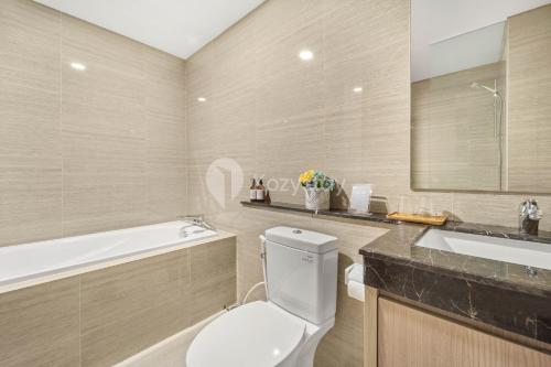 a bathroom with a toilet and a sink and a tub at VUE by Kozystay Karawaci in Dadap