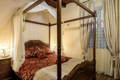 1 dormitorio con cama con dosel en Porto Del Colombo Traditional Boutique Hotel, en La Canea