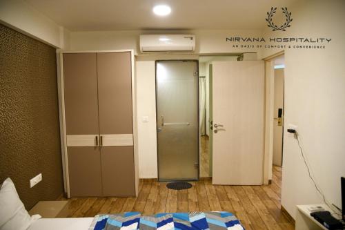 a hotel room with a door leading to a room at Rajhans Belliza Luxurious Studio Apartment in Surat