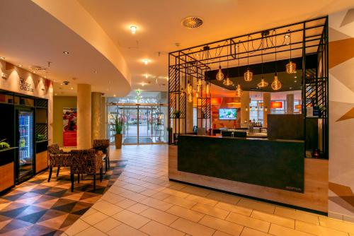 eine Lobby eines Restaurants mit einer Theke und Stühlen in der Unterkunft Best Western Premier IB Hotel Friedberger Warte in Frankfurt am Main