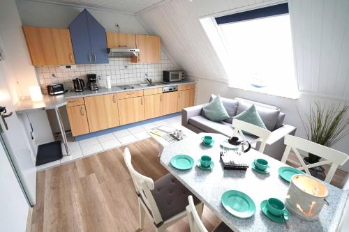 a kitchen and living room with a table and a couch at Ferienwohnung Spiekeroog in Neuharlingersiel