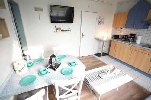 a kitchen with a table with blue dishes on it at Ferienwohnung Spiekeroog in Neuharlingersiel