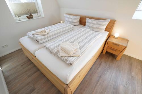 1 dormitorio con 1 cama con 2 toallas en Ferienhaus Lüttje Krabbe en Carolinensiel