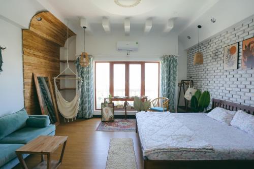 a living room with a bed and a couch at The Urban Tuy Hòa Homestay in Liên Trì (3)