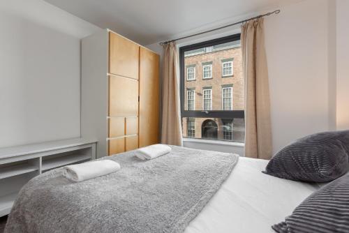a bedroom with a bed and a window at Liverpool City Centre Apartments - East Village in Liverpool