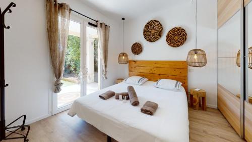 une chambre avec un lit blanc et une grande fenêtre dans l'établissement Appartement T2 : Jardin, Piscine, Parking à Sainte-Maxime, à Sainte-Maxime