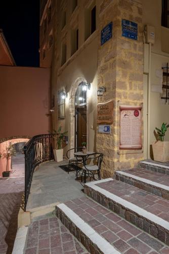 a building with a table and chairs on a patio at Porto Del Colombo Traditional Boutique Hotel in Chania Town