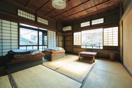a room with two beds in a room with windows at Gojo Guesthouse - Annex in Kyoto