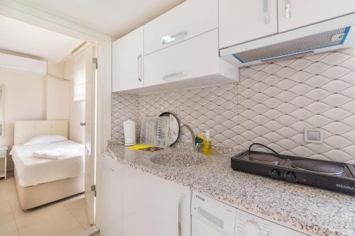 a kitchen with white cabinets and a counter top at Apartments Near to City Center and Beach in Marmaris