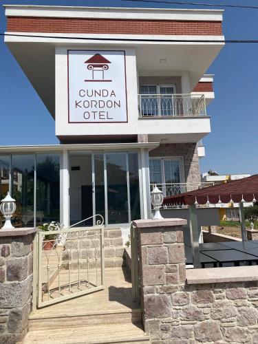 a building with a sign for a restaurant at Cunda Kordon Otel in Ayvalık