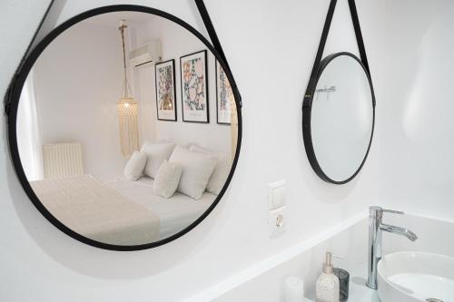 a mirror in a white bathroom with a bed at Camo’s house in Poros