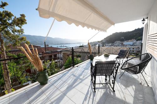 a patio with a table and chairs on a balcony at Camo’s house in Poros