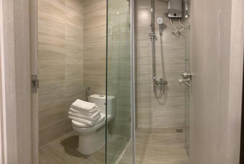 a bathroom with a toilet and a glass shower at Charm City Apartment Di An Binh Duong in Dĩ An
