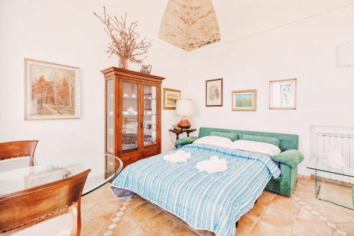 - une chambre avec un lit vert et une table dans l'établissement Appartamento fronte mare a Ospedaletti by Wonderful Italy, à Ospedaletti