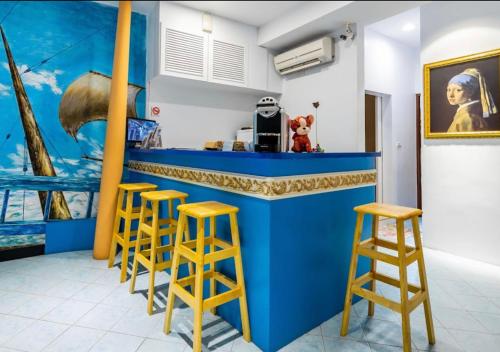 a blue bar with stools in a room at Chihkan Mansion in Tainan