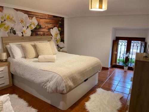 Schlafzimmer mit einem Bett mit weißer Bettwäsche und weißen Kissen in der Unterkunft Casa El Rubio in San Vicente de la Sonsierra