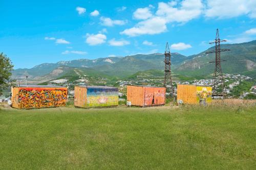 a group of containers in a field with mountains in the background at Tevra Hotel, Top of the Mountain, Camping, Nature, Ijevan, Dilijan in Ijevan