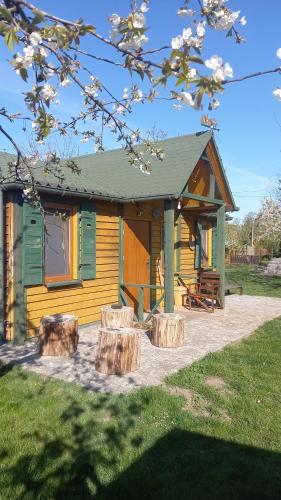 a cabin with three logs in front of it at Domek Wilamów in Wilamów