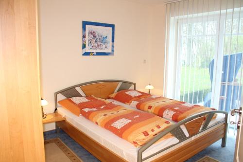 2 camas individuales en un dormitorio con ventana en Ferienhaus am Meer Katharinenhof, en Katharinenhof