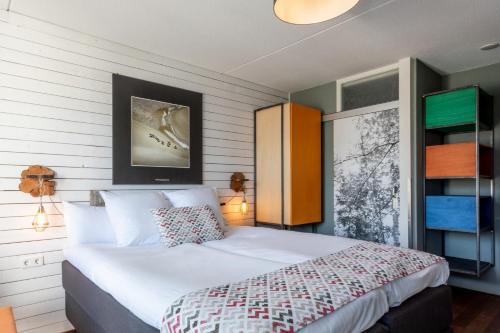 een slaapkamer met een groot wit bed in een kamer bij Strandhotel Westduin in Koudekerke