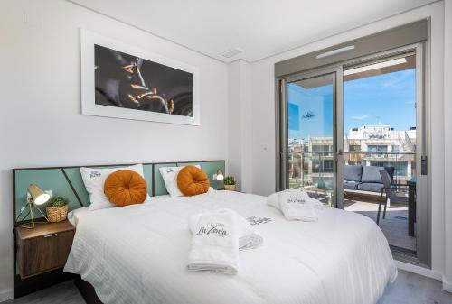 a bedroom with two beds and a large window at La Zenia Cocoon - Luxury Penthouse with jacuzzi, 2 pools, indoor heated pool, sauna, gym, playstation in Orihuela Costa