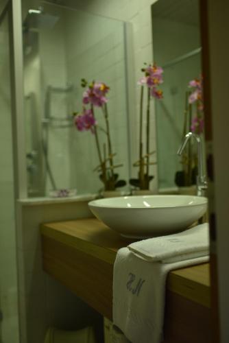 リド・ディ・イエゾロにあるHotel Negrescoのバスルーム(シンク、鏡、花付)