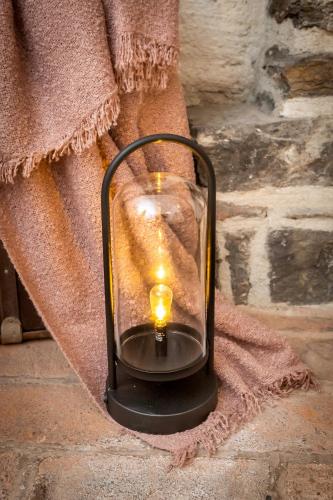 a candle in a glass lantern sitting on a towel at Penzion Maštal in Český Krumlov