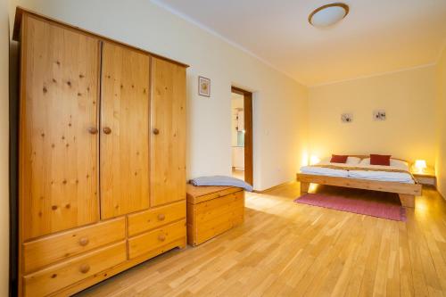 a bedroom with a bed and a large wooden cabinet at Penzion Maštal in Český Krumlov
