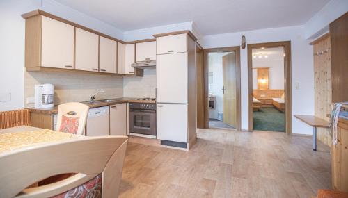a kitchen with white cabinets and a counter top at Kathrin Apartments - Kapplerhof in Kappl