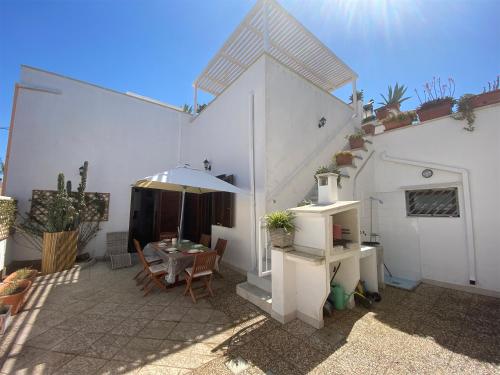 a patio with a table and chairs and a building at Casa Rosario - Villetta Indipendente in Felline